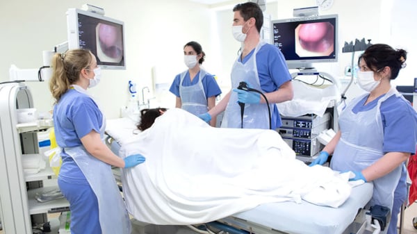 Doctors surround patient on bed during endoscopy